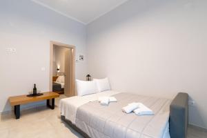 a bedroom with a large white bed and a table at Pantzos House in Paradisos