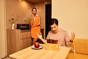 a woman standing next to a man eating a piece of cake at Section L Yushima-Ueno in Tokyo