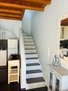 een trap in een keuken met witte muren en houten plafonds bij Aliktypo Studios in Livadion