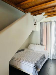 a white bed in a room with a window at Aliktypo Studios in Livadi