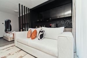 um sofá branco com almofadas na sala de estar em Fine Living Mai Tai em Nairobi