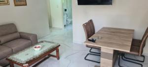 una sala de estar con una mesa y un sofá en Apartment Blue Adriatic Tivat, en Tivat