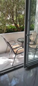 een patio met stoelen, een tafel en een raam bij Apartment Blue Adriatic Tivat in Tivat