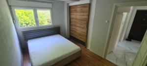 een kleine slaapkamer met een bed en een raam bij Apartment Blue Adriatic Tivat in Tivat
