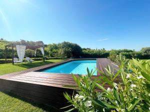 Marano di Valpolicella的住宿－Relais Valpolicella B&B，庭院旁的一个带木甲板的游泳池