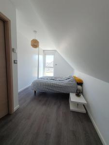 a white room with a bed and a table at Le 6 : maison individuelle au cœur de l'Alsace in Turckheim