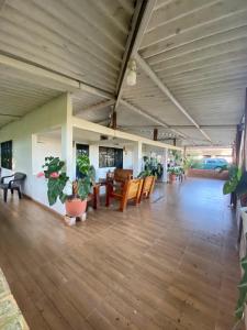 una gran sala de estar con suelos de madera y macetas. en Hacienda Veracruz en Villagarzón
