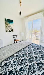 una camera con un letto bianco e nero e una sedia di Face a la mer Fleury a Fleury
