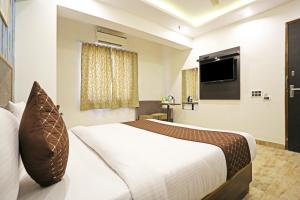 Hotel GL Suites Near Delhi Airport tesisinde bir odada yatak veya yataklar