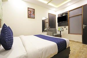 een hotelkamer met een bed en een stoel bij Hotel GL Suites Near Delhi Airport in New Delhi