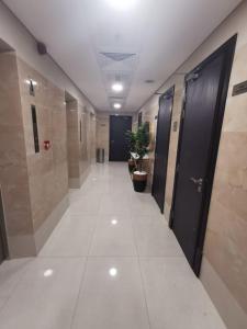 a corridor of a hallway with a door and plants at NEW DREAM PLAZA HOTEL APARTMENT L.L.C in Dubai