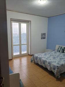 um quarto com uma cama e uma grande janela em Alloggio Turistico Montefiascone em Montefiascone