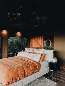 a bedroom with a large bed and a window at Drift Off Grid Luxury Eco Glamping in Tarakohe