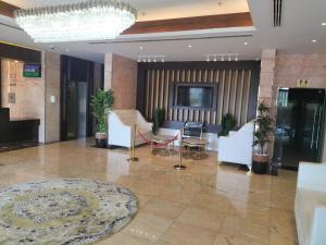 a lobby with white furniture and a chandelier at NEW DREAM PLAZA HOTEL APARTMENT L.L.C in Dubai