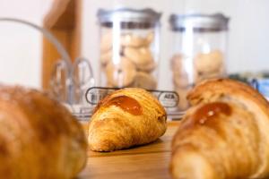 een groep croissants zittend op een houten tafel bij B&B a due passi dal mare in Caulonia Marina