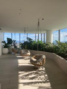 Luxury Casino Apartment in Broadbeach Island في غولد كوست: مجموعة من الأراجيح في مبنى به نوافذ