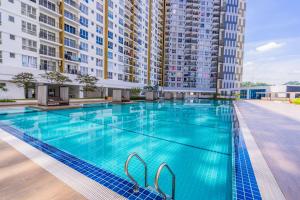 una piscina con un gran edificio en el fondo en Zen 3-bedroom w pool 6 pax - Semarak en Kuala Lumpur