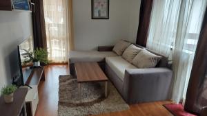 a living room with a couch and a coffee table at 500м. от лифта Сладък дом в Белведере СПА комплекс in Bansko