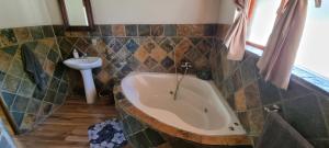 a bathroom with a large tub and a sink at Mothopo Game Lodge in Modimolle