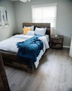 a bedroom with a bed with a blue blanket on it at 1 Bedroom Stylish Oasis in Omaha