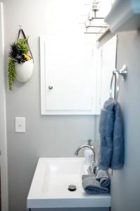 a white bathroom with a sink and a mirror at 1 Bedroom Stylish Oasis in Omaha