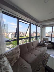 a living room with a couch and large windows at Dilaver-Apart in Istanbul