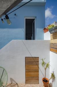 ein weißes Haus mit einer Holztür im Hof in der Unterkunft Little Bispo Apartments in Vila do Bispo