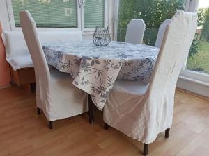 a dining room table with white chairs and a table cloth at Casa Lauda in Pillichsdorf in Pillichsdorf