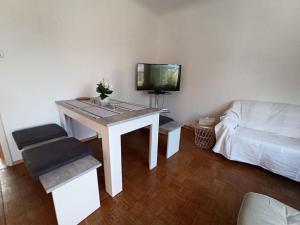 a living room with a table with a tv and a couch at Casa Lauda in Pillichsdorf in Pillichsdorf