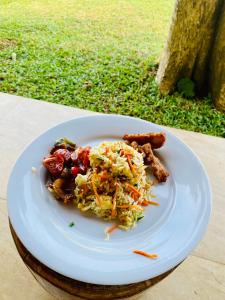 a white plate of food on a table at Lake View Cottage in Tissamaharama