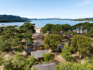 eine Luftansicht eines Resorts mit Strand und Bäumen in der Unterkunft Camping Golfo Di Sogno in Porto-Vecchio