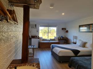 ein Schlafzimmer mit einem Bett und ein Wohnzimmer in der Unterkunft Vacy Hunter Valley Lodge in Vacy