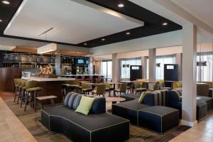 a lobby with a bar and a restaurant with chairs at Courtyard San Jose Cupertino in Cupertino