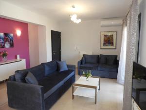 ein Wohnzimmer mit 2 blauen Sofas und einem Tisch in der Unterkunft Stadium Sea Beach Apartment in Kissamos