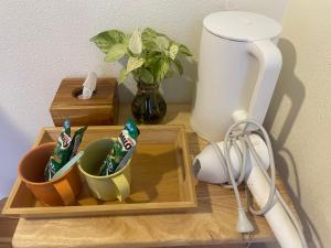 a wooden tray with cups and a blender on a table at KeawKangNa Farmstay แก้วก๋างนา ฟาร์มสเตย์ in Ban Chong (1)
