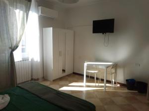 1 dormitorio con cama, mesa y TV en IL GIARDINO en La Spezia