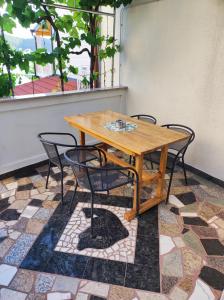einen Holztisch und Stühle auf einer Terrasse in der Unterkunft Apartmani Anđela Kordić in Rab