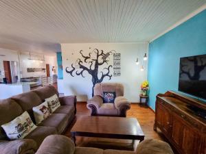 沙比耶的住宿－Sabie Peak View，客厅配有沙发,墙上有一棵树