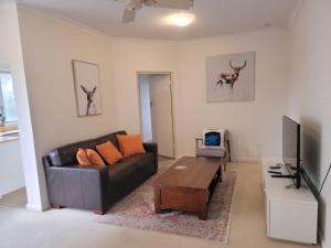 salon z czarną kanapą i telewizorem w obiekcie Close to the famous Bondi Beach in Australia w mieście Sydney