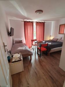 a bedroom with two beds and a desk and a table at Pod Żurawiem Stegna in Stegna