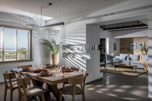 comedor y sala de estar con mesa y sillas en Villa Ete Premier Luxury Villa en Stalida