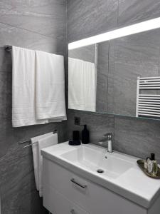 uma casa de banho com lavatório, espelho e toalhas em Montreux Luxury Suite em Montreux
