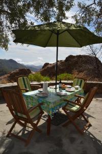 un tavolo con due sedie e un ombrellone verde di Casa Cueva El Pedregal Tejeda a Tejeda