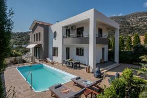 a villa with a swimming pool and a house at Villa Ete Premier Luxury Villa in Stalís