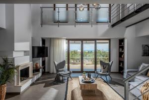 a living room with a couch and chairs and a fireplace at Villa Ete Premier Luxury Villa in Stalida