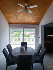 a dining room with a table and a ceiling fan at Apartman Lucy in Slatine +9 photos