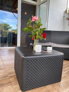 a black wicker table with a vase of flowers on it at Bukhta in Vapnyarka