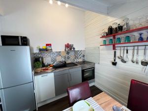 uma cozinha com um frigorífico e uma mesa com cadeiras em Ferienhaus Wieden am Deich em Hofe