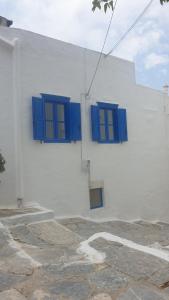 a white building with blue windows on it at Stathis Apart 2 in Amorgos