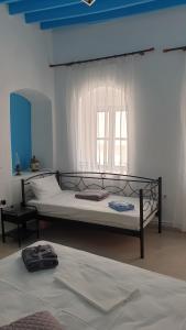 a bedroom with two beds and a window at Stathis Apart 2 in Amorgos